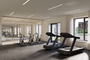 A gym with treadmills, exercise bikes and a view of the outside at Roxy Apartments, Ontario